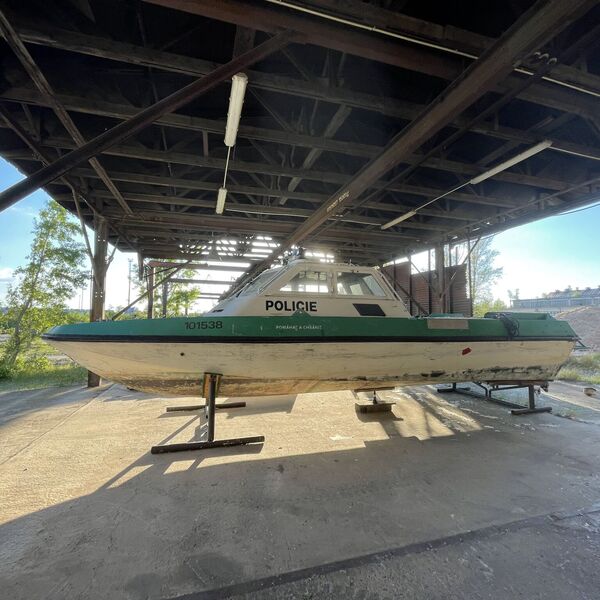 opuštěná opravna lodí s policejním člunem